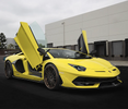 Yellow Lamborghini with scissor doors open and no front number plate.