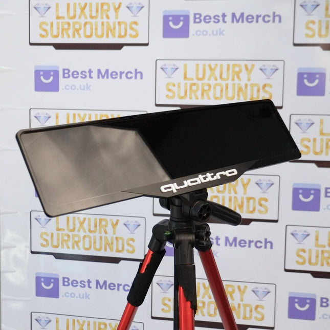 White Quattro Plate Holder - Luxury Number Plate Holder mounted on a tripod, ideal for Audi vehicles, shown against branded backdrop.