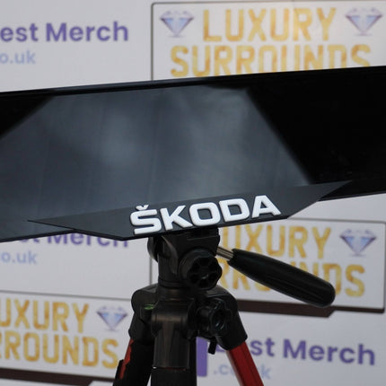 Close-up of White Skoda Badge Plate Holder showcasing the bold Skoda logo, designed for stylish number plate mounting on Skoda vehicles.
