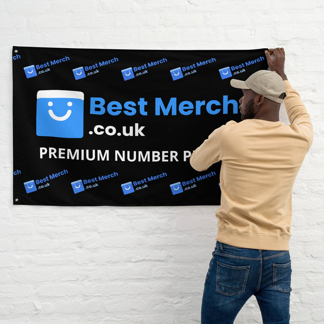 Best Merch Flag featuring BestMerch.co.uk logo and 'Premium Number Plates' text, displayed on a white wall by a man in casual wear.