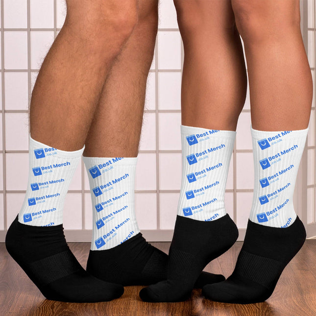 Socks - Best Merch Branded white crew socks with blue logo and text, worn by two people standing on wooden floor. Ideal for casual merch apparel.