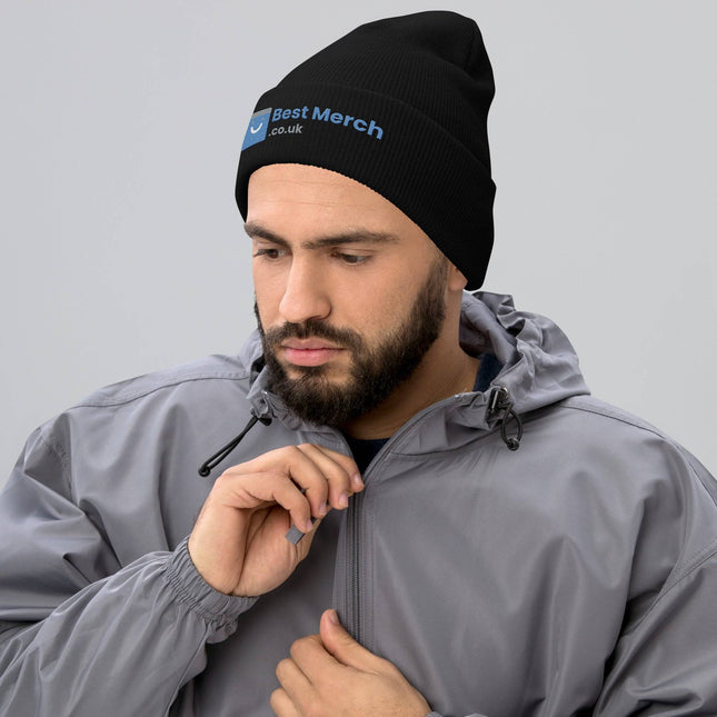 Cuffed Best Merch Beanie in black with embroidered blue and white logo, worn by man in gray jacket. Stylish winter merch accessory.